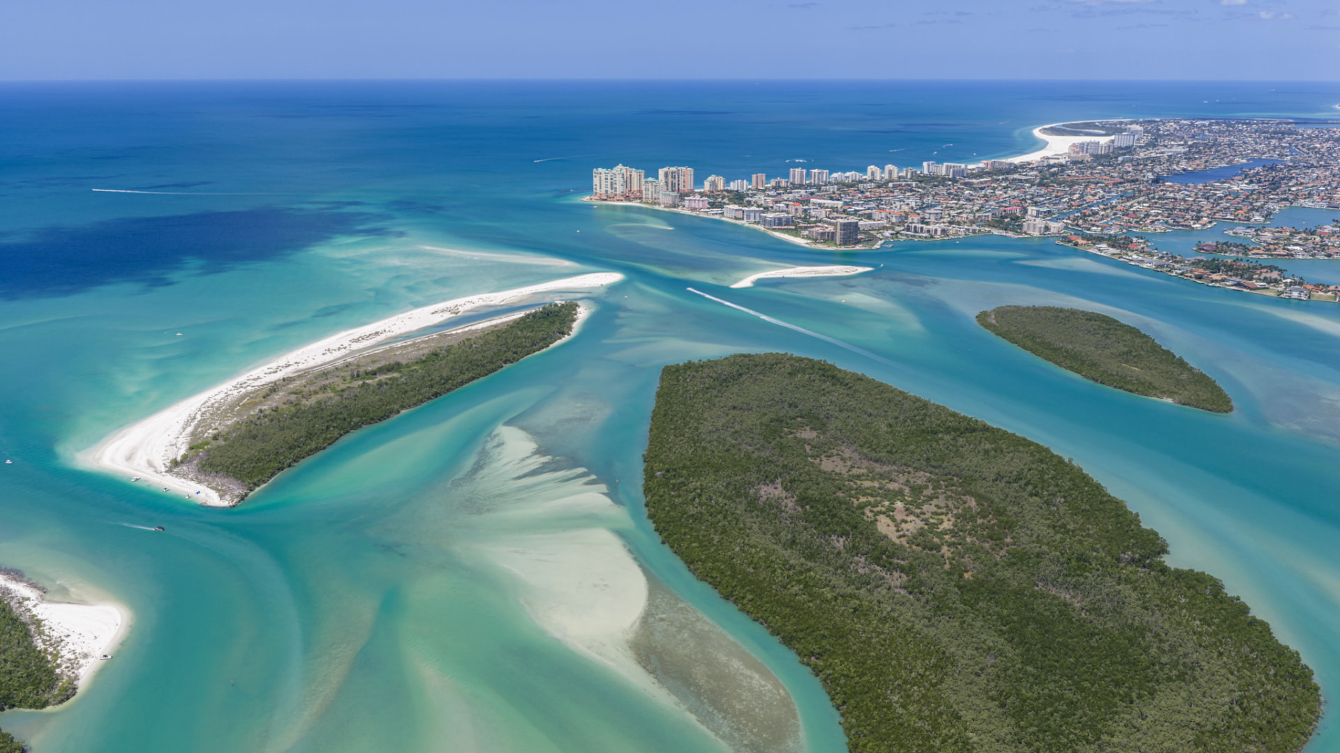 Aerial drone photo of Marco Island's turquoise passes, sandbars and mangrove islands with the skyline in the distance