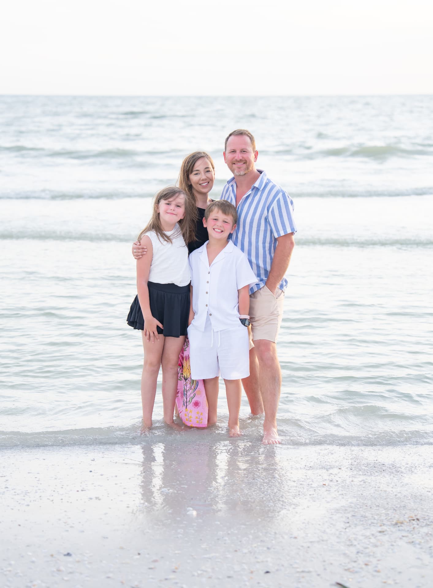 Family of four standing in the gulf water for a vacation portrait