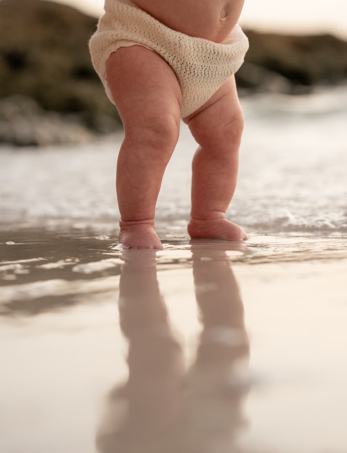 Baby's first steps in the shallow water, photographed low to the shoreline